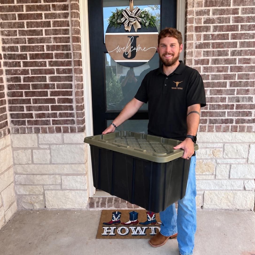 Brennon, owner of Texas Totes, carrying a moving tote